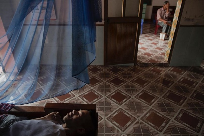 Lai Van Manh, who has physical and mental disabilities, rests in bed.